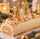 Bûche de Noël blanche élégante décorée de deux sapins dorés sur pique, de perles dorées et de petites étoiles, dans une ambiance festive et chic. 🎄💕